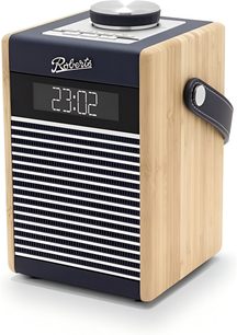 Roberts Rambler Midi bordradio i mørkeblå farve, rektangulært kabinet med bambus sider og en front med horisontal hvid og mørkeblå gitter, der er kronet med et digitalt display, toppen er udstyret med en stor sølvfarvet cirkulær drejeknap og knapper, mørkeblå sidebælte, set fra højre forside i trekvarts vinkel