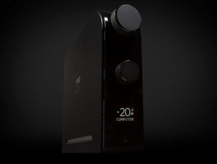 Svart metallisk ljudanordning med två knappar, skärm -20 dB COMPUTER, hörlursuttag, trekvarts vy från framifrån