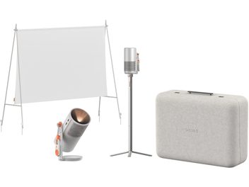 Set XGIMI MoGo 4 Laser Outdoor Collection grigio argento in metallo e tessuto, vista frontale d’insieme, composto da videoproiettore cilindrico con griglia forata e comandi arancioni, treppiede telescopico coordinato, grande schermo di proiezione bianco con cornice e valigia rigida goffrata grigio chiaro