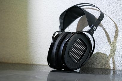 Sluchátka Hifiman Arya s otevřenou konstrukcí, černé obdélníkové náušníky s mřížkou, černý perforovaný oblouk, reflexní povrch
