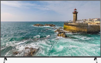 Panasonic TX-49FX700 fladskærms-TV, der viser en detaljeret maritim scene med oprørt hav, klipper og et fyrtårn