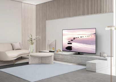 Panasonic TX-48JZ980E-fladskærm, der viser et billede af japanske trin i vandet ved solnedgang i en moderne stue