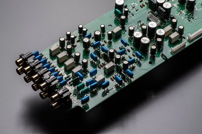 Zelený tištěný spoj s mnoha modrými a stříbrnými elektronickými součástkami, detailní pohled zepředu