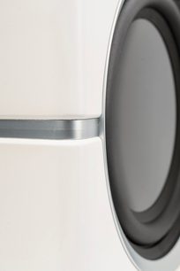 Subwoofer Dynamo 10 blanco lacado, vista lateral de cerca, superficie blanca brillante, borde metálico, membrana circular gris