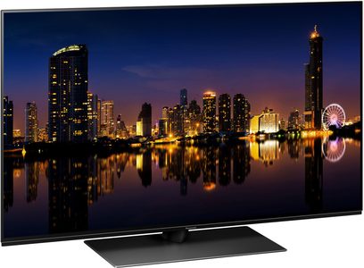 Televizor Panasonic TX-48MZ1500E zobrazující noční výhled na osvětlené mrakodrapy a jejich odrazy ve vodě