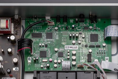 Vihreä piirilevy, jossa on erilaisia elektronisia komponentteja, lähikuva edestä