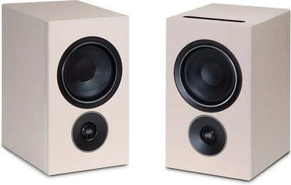 Par PSB reolhøjttalere i beige sandstone, enkel front med stor sort basenhed og central diskant