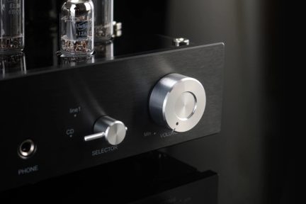 Amplificatore audio valvolare nero con grande manopola del volume argentata e selettore frontale