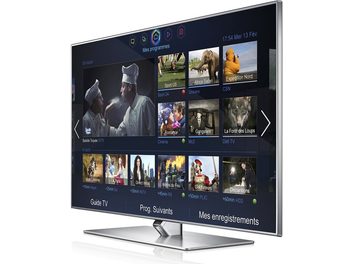 Samsung UE60F7000 fladskærms-TV, der viser en menu med miniaturebilleder af TV-programmer, set forfra på sort baggrund