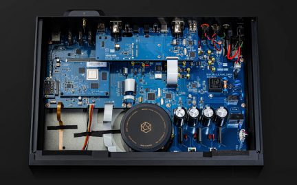 Set fra oven af et blåt printkort med elektroniske komponenter, stikforbindelser, cylindriske kondensatorer og interne ledninger