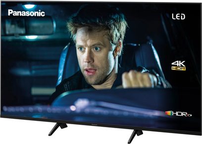 Panasonic TX-50GX700E 4K HDR LED-tv set forfra, tændt skærm viser ansigtet af en mand med blå øjne
