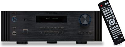 Sort Rotel RA-6000 stereo hi-fi-forstærker med sort front, knapper og stik, set forfra, og sort fjernbetjening ved siden af