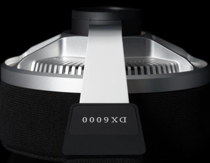 Close-up of a black and silver device in metal and fabric, radial finned grille, white strap, label “DX 6000”