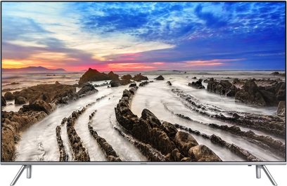 Samsung UE55TU7005-TV som visar en slingrande stenig strand vid solnedgången med en färggrann molnig himmel