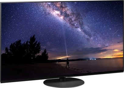 Panasonic TX-65JZ1000E-fladskærm, der viser et natlandskab med stjernebestrøet himmel og Mælkevejen over en sø, set forfra