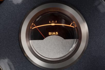 Nærbillede forfra af det cirkulære BIAS-vu-meter i glas og sølvfarvet metal, baggrundsbelyst i orange, integreret i Cayin CS-845A Reference sølv rørforstærker
