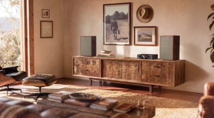Coppia di diffusori da scaffale vintage con frontale verde oliva, appoggiati su una credenza in legno in un accogliente soggiorno