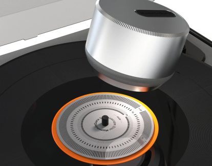 Pladespiller med sølvfarvet HumminGuru-modul og stroboskopskive med orange kant, set tæt på