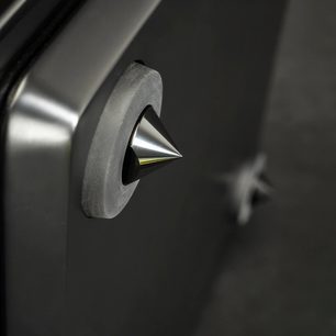 Dynamo 12 subwoofer i sort lak, skinnende konisk metalspids monteret på en mat cirkulær base, nærbillede fra siden