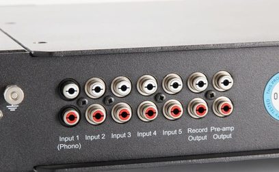 Røde og sorte RCA-lydstik samt 6,35 mm jackstik på en sort metalbagpanel på en elektronisk enhed