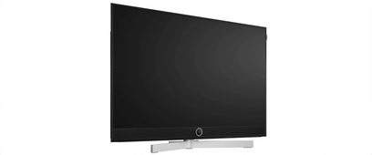 Τηλεόραση Loewe Stellar 65 DR+ μαύρη επίπεδης οθόνης με ενσωματωμένη μπάρα ήχου και ασημί βάση σε μπροστινή όψη