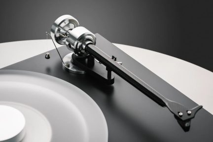 Braço de leitura para prato de vinil em carbono com contrapeso em alumínio sobre base preta de design elegante