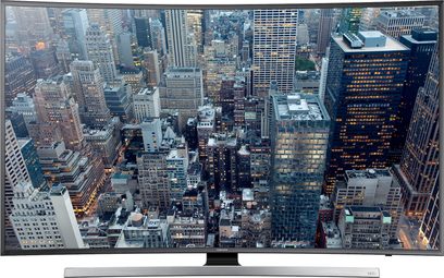 Samsung UE65JU7500 tv der viser en luftoptagelse af en tætbebygget by med mange skyskrabere, set forfra