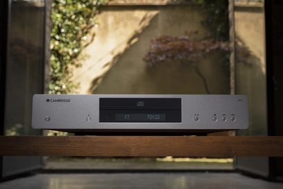 Lettore CD Cambridge Audio CXC V2 grigio antracite visto frontalmente, posato su una superficie in legno, in un ambiente interno
