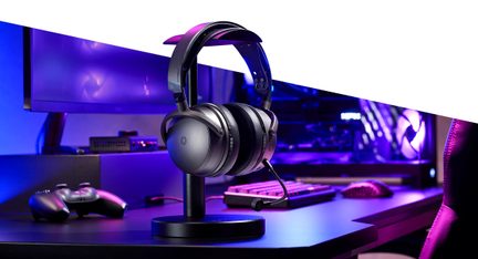 Cuffie gaming wireless nere e grigie con microfono su supporto, scrivania PC RGB illuminazione viola
