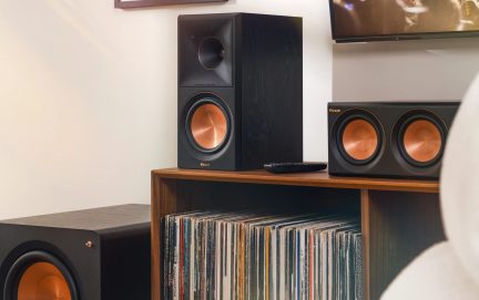 Sort Klipsch-hjemmebiografsæt med kobberfarvede højttalere, central reolhøjttaler og subwoofer