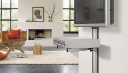 Hvid ophængt TV-møbel med skuffe, i en moderne stue med pejs, rød sofa, maleri og store vinduer