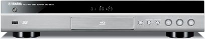 „Yamaha BD-S673" Blu-ray grotuvas, titano spalvos, priekinis skydelis sidabrinis, mėlynas ekranas, juodi mygtukai ir jungtys, vaizdas iš priekio