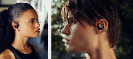 Two profiles with wireless in-ear plastic earphones, one black, one black and orange, with ear fins for secure fit