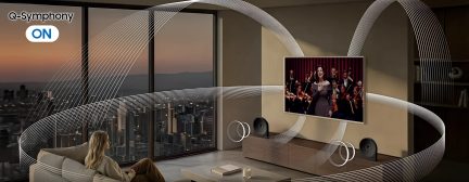 Nástěnný televizor Samsung v moderním obývacím pokoji s prostorovým audiosystémem Q-Symphony a panoramatickým výhledem na město