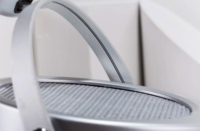 Tæt på bøjlen og toppen af den åbne hovedtelefon Hifiman Deva, i børstet sølvfarvet metal