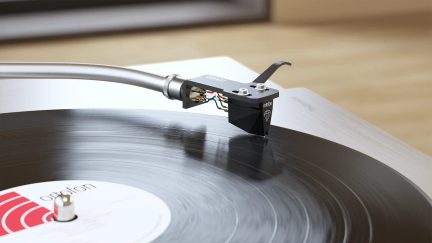 Ortofon adata uz vinila atskaņotāja tonarma virs rotējošas melnas plates tuvplānā