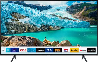 Samsung UE55RU7175-TV som viser et landskap med en blågrønn isbre og brune steiner, med en person som står oppreist