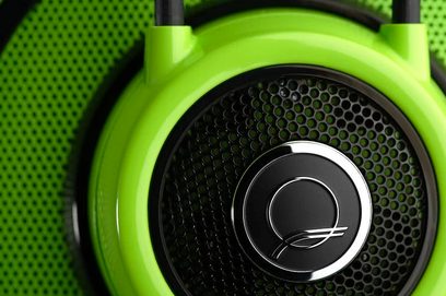 Atviras ausinių modelis AKG Q 701 žalios spalvos, šoninis vaizdas, juoda šešiakampė garsiakalbio grotelė ant žalios ausinės, sidabrinis logotipas