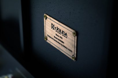 Rektangulær metalplade med indgraveret tekst "Jolida JD-102A Integrated Amplifier" monteret på en mat sort overflade