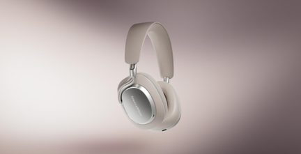 Beige circumaurale hovedtelefoner i plastik og metal, ovale ørekopper med sølvplade, polstret hovedbøjle, trekvartsvinkel visning