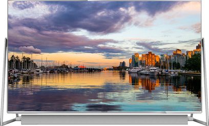 Téléviseur Panasonic TX-50DX800E affichant un paysage urbain avec marina, bateaux et gratte-ciel au coucher du soleil