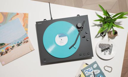 Sort Sony pladespiller set oppefra med turkisblå vinylplade på dekorativt hvidt bord