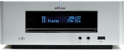 Sølvfarvet Arcam Solo Mini high-fidelity system med blå LCD-skærm, der viser "CD 12 spor VOL:33 77m 21s", set forfra