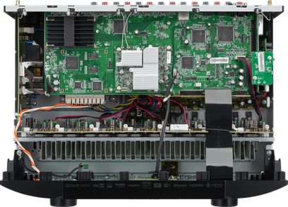 Indvendigt billede af en sort Marantz SR5015DAB hjemmebiograf-forstærker, der viser det grønne printplade med talrige komponenter
