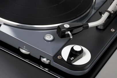 Thorens TD 124 DD siyah plak çalar, plak tabağı ve okuma kolu ile kartuşun 3/4 ön görünüşüne yakın çekim