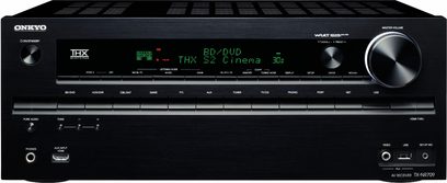 Schwarze Vorderseite eines Onkyo TX-NR709 Heimkino-Verstärkers mit zahlreichen Tasten, Drehknöpfen und einem zentralen grünen Display, das Informationen anzeigt