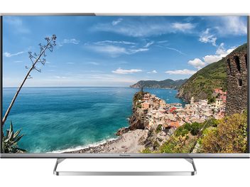Telewizor Panasonic TX-42AS650E przedstawiający nadmorski krajobraz z kolorową wioską, klifami i turkusowym morzem pod zachmurzonymi niebem