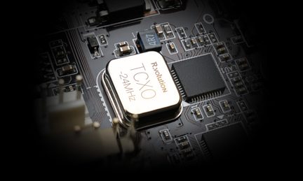 Nærbillede af et printkort med en rektangulær gylden TCXO 24MHz komponent, sorte chips, metalforbindelser