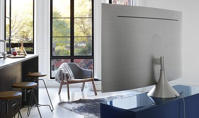 Vægmonteret TV-beslag fra Samsung VG-SGSM11S/XC i grå metal, rektangulær vertikal form, leddet arm, monteret på væggen i et moderne interiør