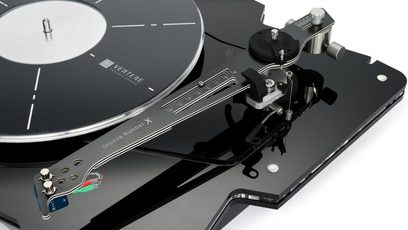 Giradischi hi-fi Vertere Acoustics Pack Raw DGX nero in acrilico lucido visto di tre quarti dall’alto, con piatto grigio antracite con indicatori bianchi, braccio di lettura metallico Groove Runner X con cavi a vista, contrappeso e fissaggi metallici su base smussata